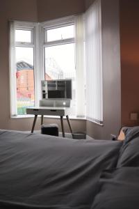 a bedroom with a computer on a desk in front of a window at Kop View in Liverpool