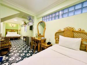 a hotel room with a bed and a desk at Spring House Saigon central park in Ho Chi Minh City