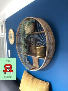 a wicker shelf hanging on a wall with plants at T2 - Tram direct Strasbourg Centre Ville en 11 min - PARKING GRATUIT in Schiltigheim