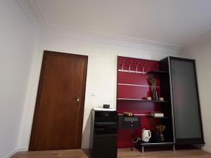 una stanza con una porta e una parete rossa di Chambre meublé à Belval a Sanem