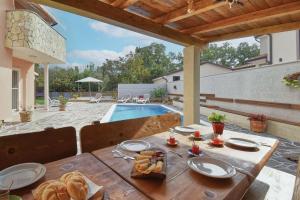 a wooden table with food on it next to a pool at Holiday House Amna in Kaldanija
