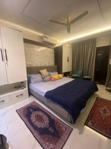 um quarto com uma cama grande e um cobertor azul em Krishna Villa em Bhubaneshwar