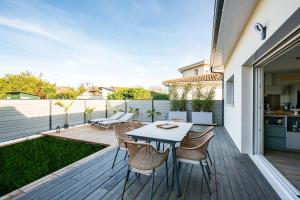 un patio con mesa y sillas en una terraza en Douce echappee a Andernos-les-Bains, en Andernos-les-Bains