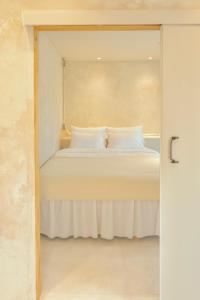 een slaapkamer met een bed met witte lakens en kussens bij Moseul Jeju in Jeju-stad