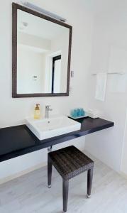 a bathroom with a sink and a mirror at COZYSTAY IN トゥリバー宮古島 in Miyako Island