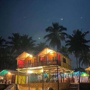 a house with lights on the beach at night at Nana's Nook in Agonda