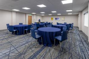 une salle de conférence avec des tables et des chaises bleues dans l'établissement Holiday Inn Express Hotel & Suites Center Township, an IHG Hotel, à Monaca