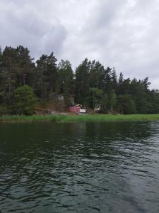 - une vue sur un lac avec une maison en arrière-plan dans l'établissement Topsala Seaside, à Houtskari