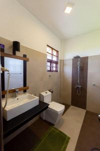 y baño con lavabo, aseo y ducha. en Serene Park Hotel By Ark, en Tissamaharama