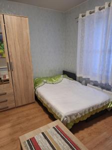 a small bedroom with a bed and a cabinet at Kambario nuoma su bendru vonios kambariu in Kaunas