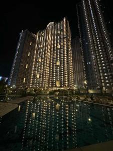 un gran edificio con una piscina de agua por la noche en Prisma Residences by La Casa Staycation, en Manila