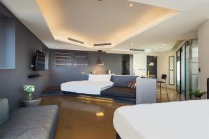 a hotel room with two beds and a couch at CHECK inn Taichung Liming in Taichung