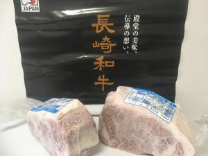 zwei Fleischstücke vor einem schwarzen Schild in der Unterkunft Exit8 Like hostel nedoko in Nagasaki