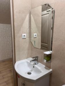 a bathroom with a sink and a mirror at Гостинично-банный комплекс Майами Люкс in Kostanay