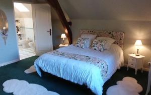 a bedroom with a large bed with two lamps and two rugs at LE MOULIN DE MERAL in Montsûrs