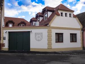 une maison blanche avec un garage vert dans l'établissement Craft Inn - Boutique Hotel, à Sibiu