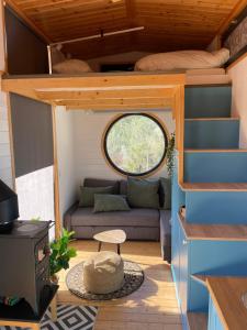 une petite maison avec un canapé et une fenêtre dans l'établissement Tiny House 'la Huerta', à Montroy