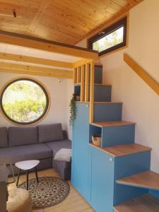 - un petit salon avec un canapé et une fenêtre dans l'établissement Tiny House 'la Huerta', à Montroy