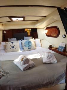 a bedroom with two towels on a bed on a boat at Hotel Boat Cardeli in Gijón