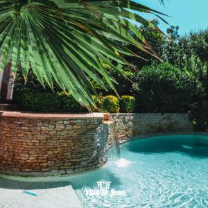 a swimming pool in a yard with a palm tree at Villa Mas de la Mer in La Ciotat