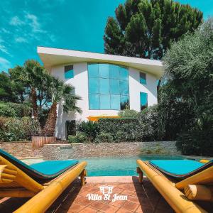 a house with a swimming pool and two lounge chairs at Villa Mas de la Mer in La Ciotat