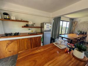 a kitchen with a wooden table and a refrigerator at Tanouy Garden in Baan Khai