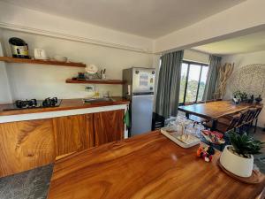 eine Küche mit einem Holztisch und einem Kühlschrank in der Unterkunft Tanouy Garden in Baan Khai