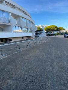 una strada vuota di fronte a un edificio di les caravelles plage sud a Le Grau-du-Roi