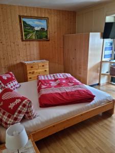 a bedroom with a bed with red pillows on it at Pension Hof zur Stilli in Davos