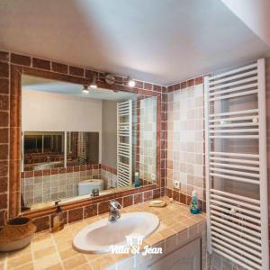 a bathroom with a sink and a large mirror at Villa Mas de la Mer in La Ciotat +50 photos