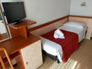 Cette petite chambre comprend un lit et une télévision. dans l'établissement Ben Hur Rimini, à Rimini