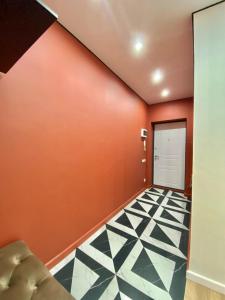 um quarto com uma parede laranja e uma porta em Однокомнатные апартаменты ЖК Auezov city 37 em Almaty