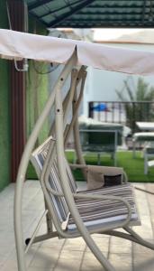 a chair under an umbrella on a patio at Alzam Residency in Nizwa