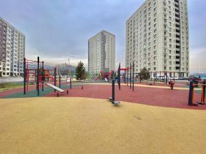 um parque infantil numa cidade com edifícios altos em Однокомнатные апартаменты ЖК Auezov city 37 em Almaty