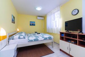 1 dormitorio con 1 cama y TV de pantalla plana en Apt ANA, Vantacici-Malinska, Island Krk en Vantačići