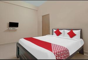 a bedroom with a large bed with red pillows at hotel high 5 in Hyderabad