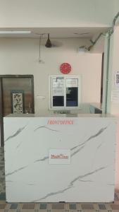 a white counter with a red clock on a wall at hotel high 5 in Hyderabad