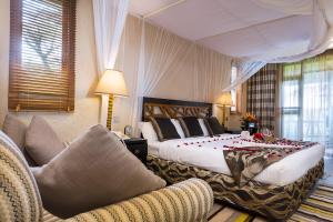 a bedroom with a large bed and two chairs at Sawela Lodges in Naivasha