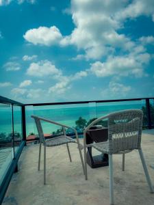 einen Stuhl auf einem Balkon mit Meerblick in der Unterkunft Tanouy Garden in Baan Khai