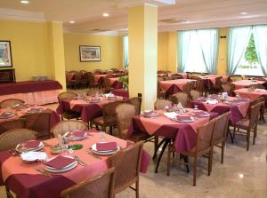 jadalnia ze stołami i krzesłami z różowymi obrusami w obiekcie Ben Hur Rimini w Rimini