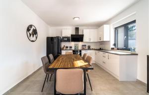 a kitchen with a wooden table and chairs at Beach Front Home In Pridraga in Pridraga