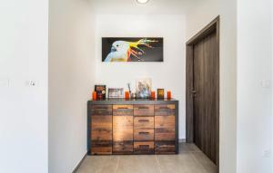 a wooden dresser in a room with a door at Beach Front Home In Pridraga in Pridraga