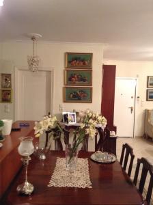 VERA’S APARTMENT في مركوبوولو: طاولة غرفة الطعام مع إناء من الزهور عليها