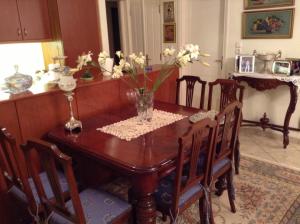a dining room table with a vase of flowers on it at VERA’S APARTMENT in Markopoulo