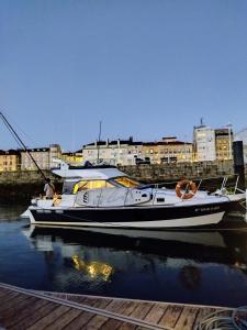 un barco sentado en el agua junto a un muelle en Hotel Boat Cardeli, en Gijón
