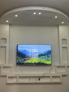 uma televisão de ecrã plano pendurada numa parede em شقة غرفتين نوم و دورة مياه و صاله كبيره ومطبخ حي الرمال بالرياض em Riyadh