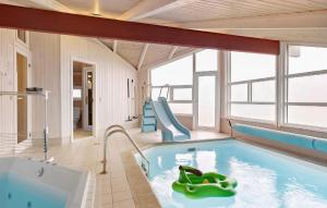 a swimming pool with a slide and a swimming tub at Cozy Home In Hjrring With Sauna in Lønstrup