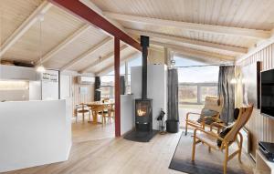 a living room with a fireplace in a tiny house at Cozy Home In Hjrring With Sauna in Lønstrup