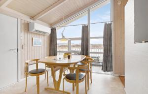 ロンストラップにあるCozy Home In Hjrring With Saunaのダイニングルーム(テーブル、椅子付)、大きな窓が備わります。