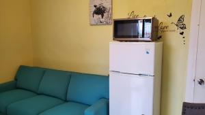 a blue couch with a tv on top of a refrigerator at Eastwood Escape in Nassau